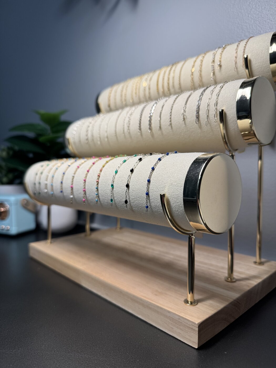 Three rolls of fine chain displayed on a wooden board